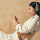 Side view of korean girl in headphones looking at phone screen, reading e-book, listening to music - PhotoDune Item for Sale