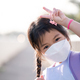 Asian child girl wearing white face mask when going to school, protecting against dust, toxic smoke. - PhotoDune Item for Sale