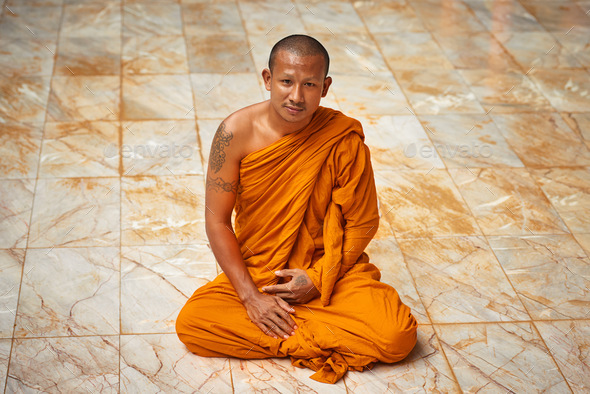 Sitting in quiet meditation. Portrait of a buddhist monk sitting on a monastary floor.