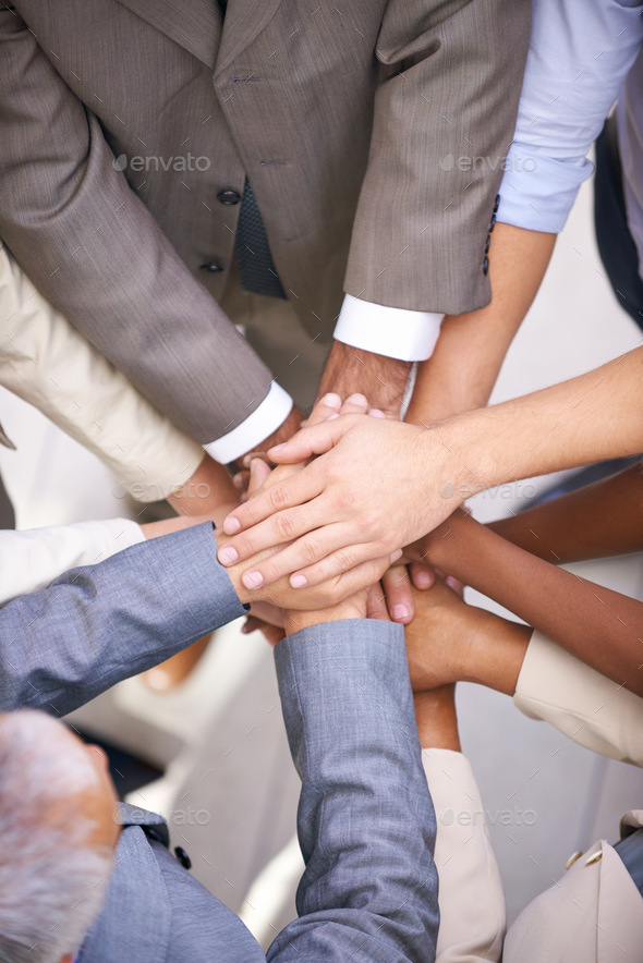 We can do this. Shot of a group of coworkers with their hands in a huddle.