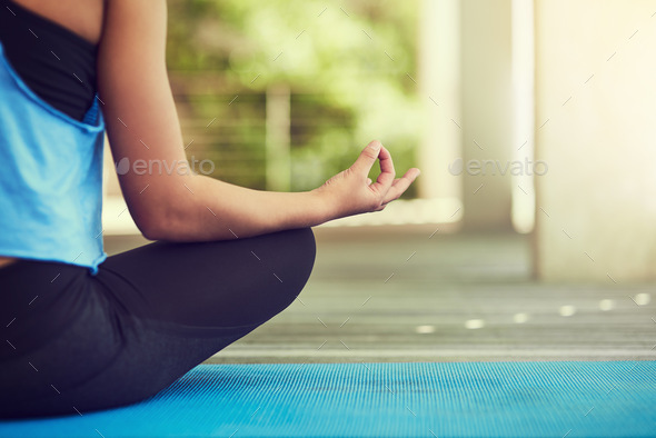 Yoga is the way of life. Cropped shot of a young woman sitting in lotus position.