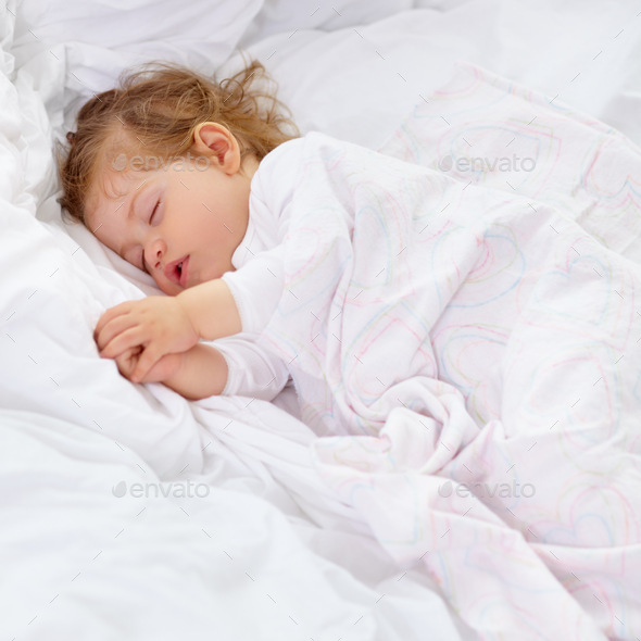 Sleep is important for development. A cute baby sleeping on the bed
