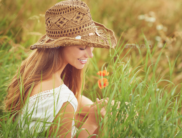 Find beauty in the smallest moments. Shot of a young woman sitting in a field in the countryside.