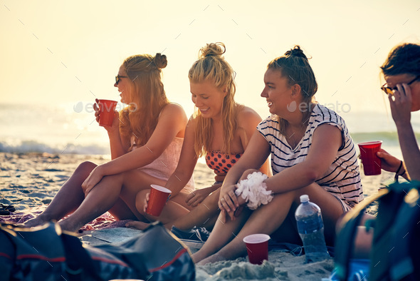 Good times and tan lines. Shot of young female best friends hanging out at the beach.
