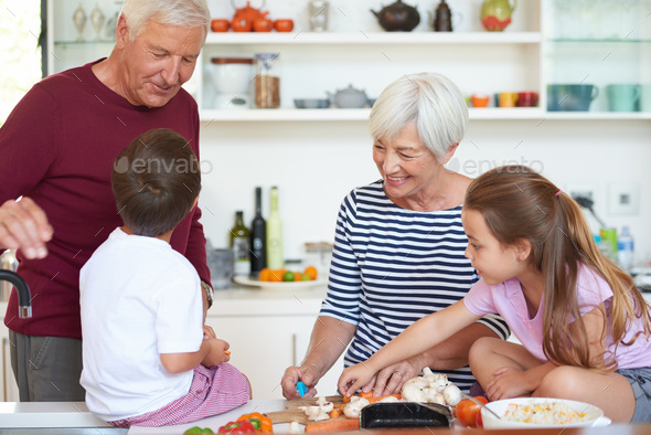 Shot Of Grandparents Preparing Dinner With Their Grandchildren In A 