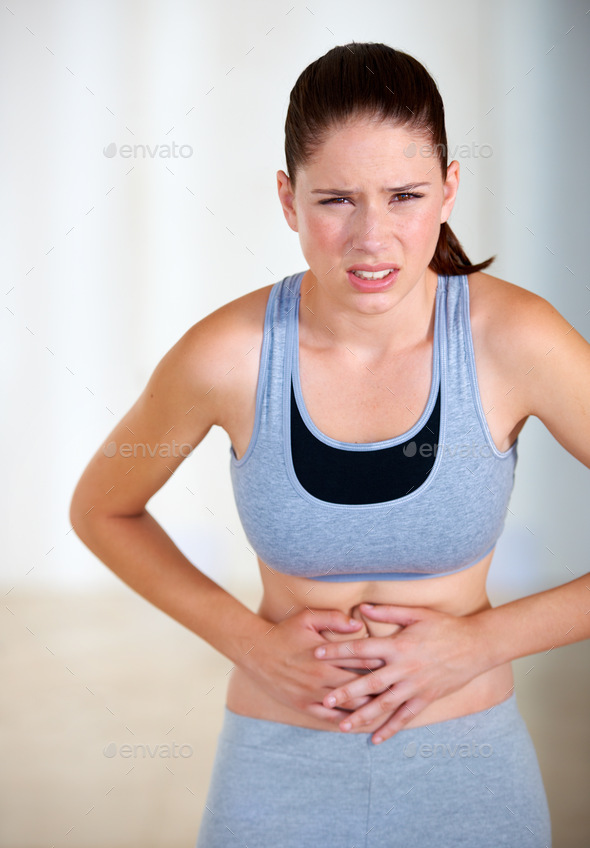 Stomach ache. Portrait of an attractive young woman holding her stomach