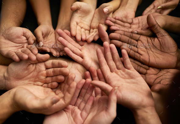 Support a good cause. Shot of a group of hands held cupped out together.