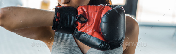 panoramic shot of sportswoman in boxing glove in sports center