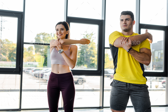 sportsman and sportswoman working out together in sports center