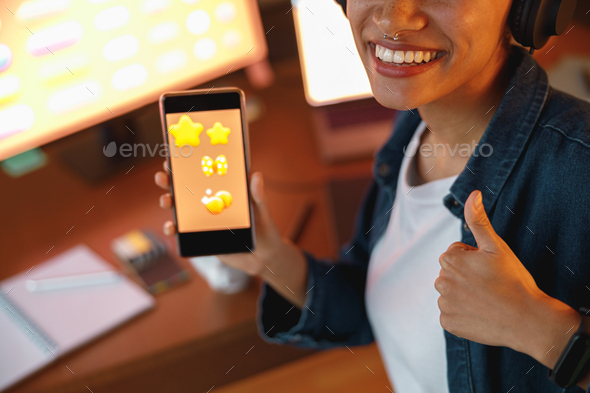 Woman graphic designer is showing smartphone during work day in home office - Stock Photo - Images