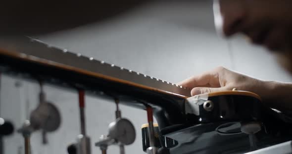 Luthier Measures the Fretboard Angle of the Electrick Guitar Neck on the Jig Repairing the Musical