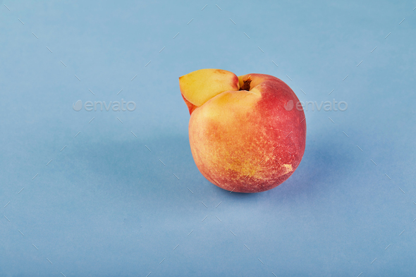 An ugly fruit or vegetable. Very ugly peach mutant on blue background.