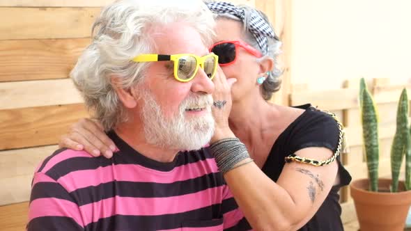 Senior old caucasian couple with alternative look and cheerful lifestyle engage and have fun alt