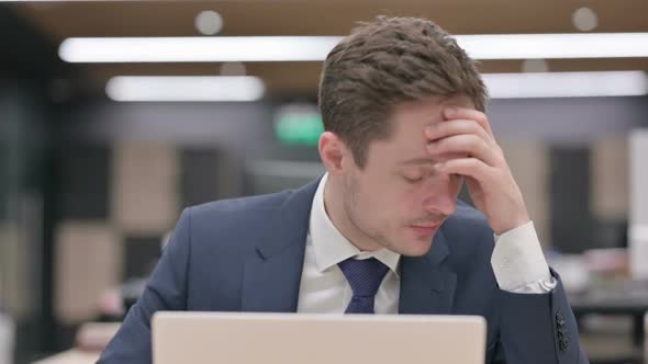 Portrait of Businessman Having Headache While Using Laptop alt