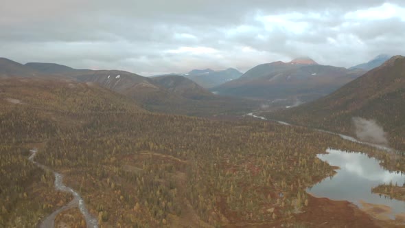 Aerial View of Autumn Colorful Forest Lakes and Swamps Under the Cloudy Sky alt