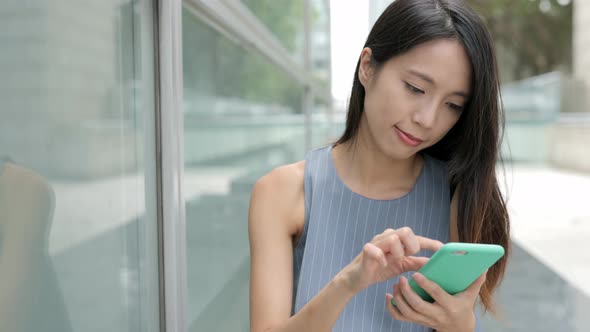 Woman using mobile phone in shopping mall alt