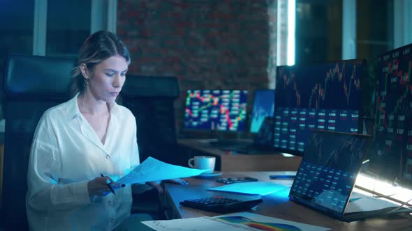 Female Broker is Drinking Coffee While Looking Into Stock Rates alt