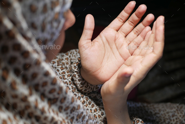 rear view of muslim women hand praying at night