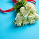Bouquet of white roses with red bow on blue background - PhotoDune Item for Sale