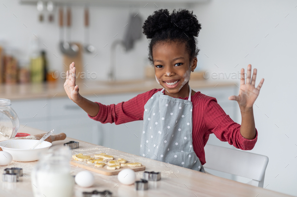 Joyful little african american girl making cookies for her family Stock  Photo by Prostock-studio
