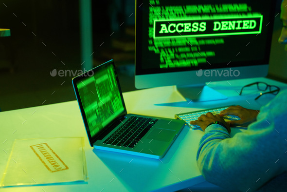 Shot of an unrecognizable hacker cracking a computer code in the dark