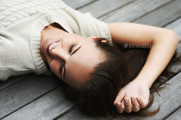 Taking it easy. An attractive young woman lying on her porch.