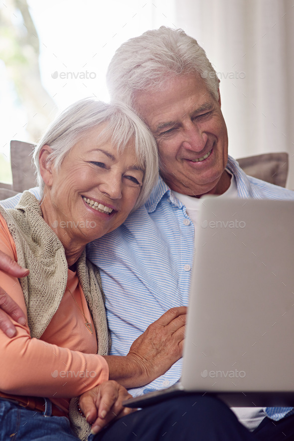 Watching romantic comedies online. Shot of a senior couple using a laptop at home.