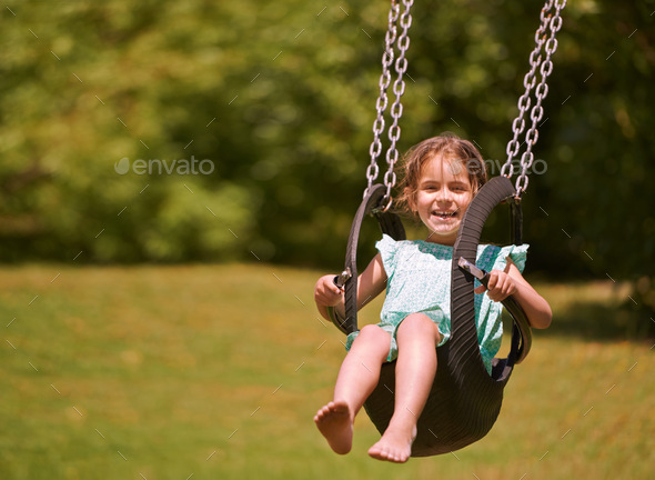 Nothing better than a swing. Shot of a young girl playing on a swing outsdie.