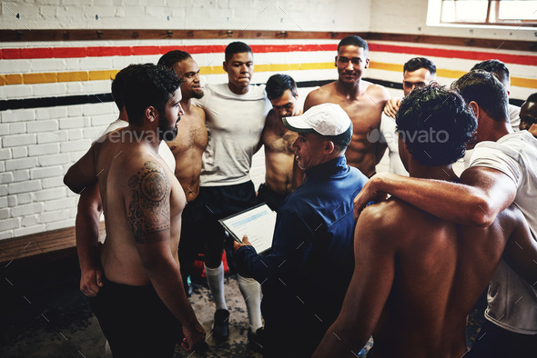 Cropped shot of a rugby coach addressing his team players in a locker room during the day