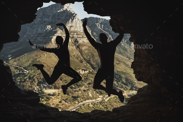 We did it. Rearview shot of a young couple jumping in excitement while hiking in the mountains.