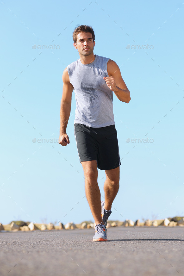 Keeping his body in great shape. Handsome young man jogging down the