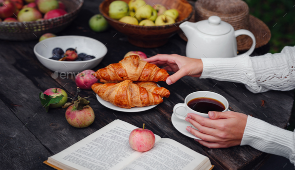 autumn flat lay female hands with coffee, apples, croissants, plums and book. - Stock Photo - Images