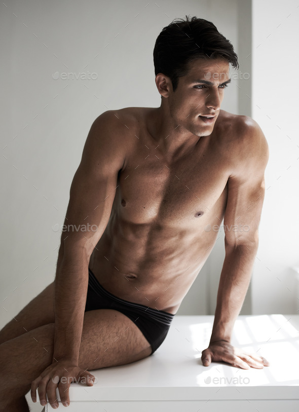 Muscles with no end. Cropped shot of a handsome young man posing in his  underwear. Stock Photo by YuriArcursPeopleimages