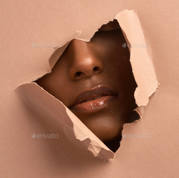 Closeup shot of an unrecognizable woman tearing through brown paper