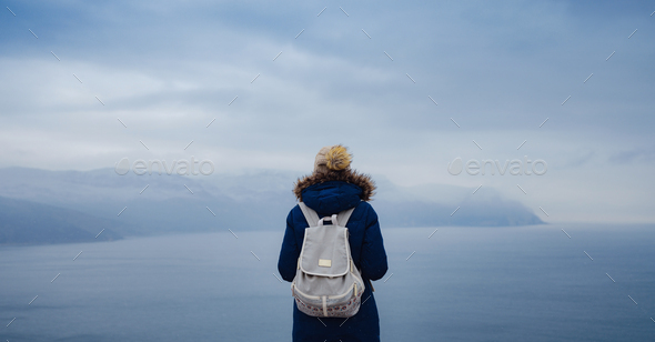 Back view of woman on shore of North sea on cold winter day. - Stock Photo - Images