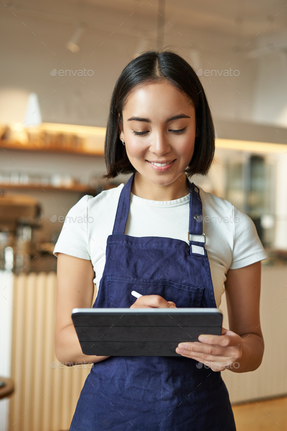 Vertical Shot Of Smiling Girl Waitress Barista In Coffee Shop Wears Blue Apron Uniform Takes 3958