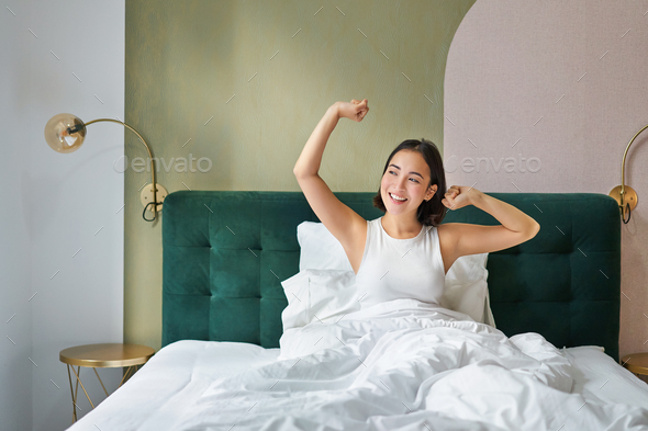 Beautiful Asian Woman Lying In Her Bedroom On Bed Stretching Hands And Looking Outside Waking 