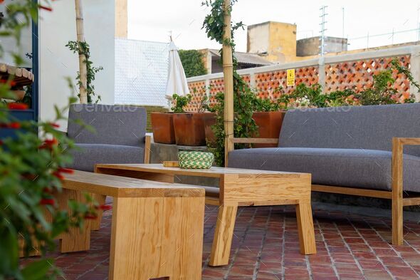 View of Patio outdoor living space with couch and coffee table in background of greenery yard