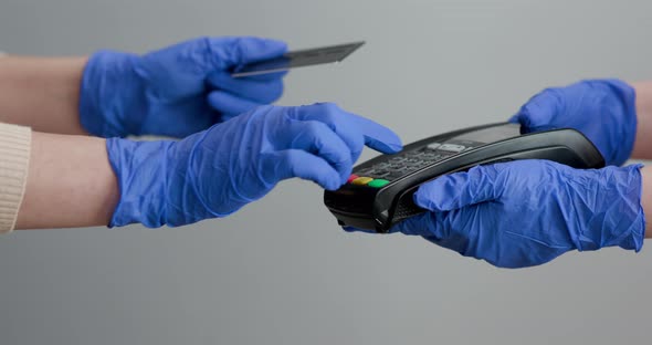 Woman Hand in Gloves with Credit Card Swipe Through Pos Terminal and Enter Pin Code