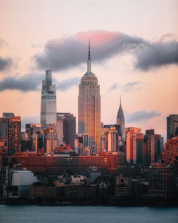 Beautiful view of the Empire State Building under a cloudy pink sky at sunset in New York City