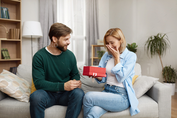 Happy Man Presenting Gift To Wife. Man Presenting Good Unexpected Present