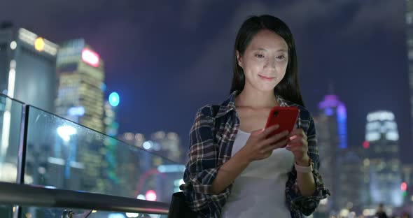 Woman use of mobile phone in city of Hong Kong at night