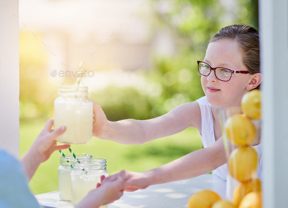 Here you go - enjoy. Cropped shot of a little girl selling lemonade from her stand outside. - Stock Photo - Images