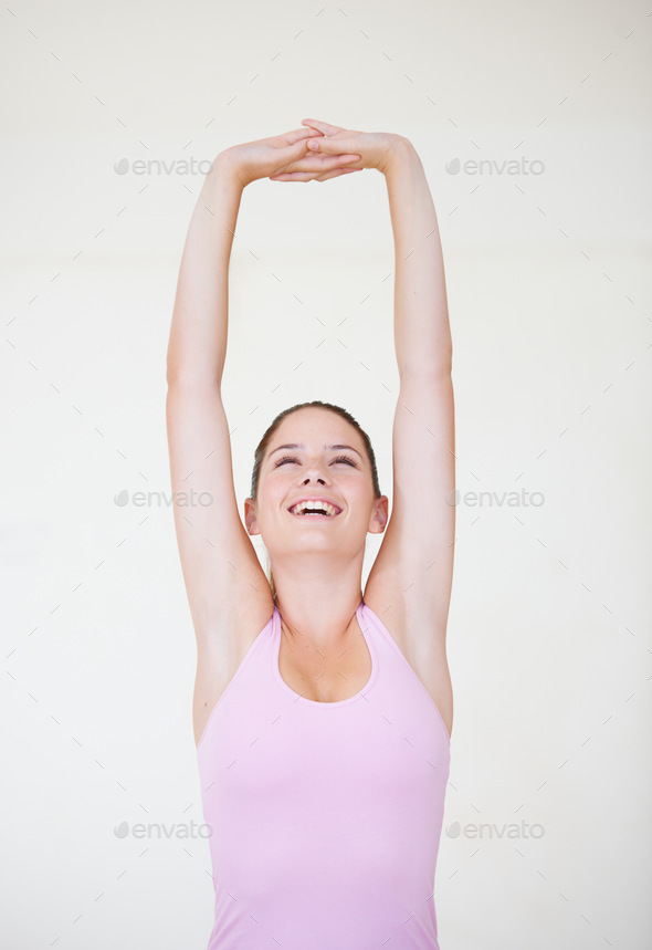 Great body conditioning. Shot of a young woman stretching her arms