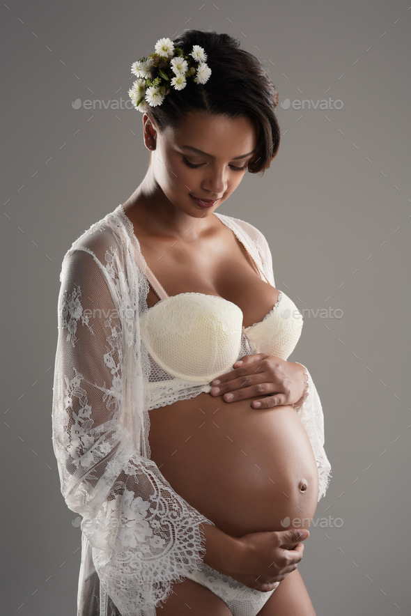 Studio shot of a beautiful young pregnant woman posing in underwear against  a gray background Stock Photo by YuriArcursPeopleimages