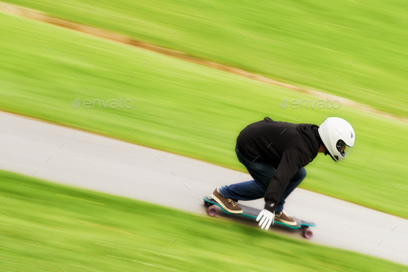He lives life in the fast lane. Shot of a man skateboarding down a lane at high speed on his board.