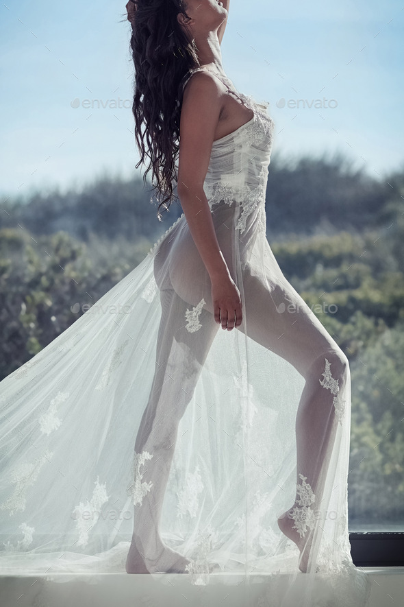 Transparent beauty. Full length shot of a young woman posing in a sheer  dress outside. Stock Photo by YuriArcursPeopleimages