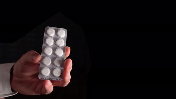 Plate With White Pills In The Doctors Hand On A Black Background