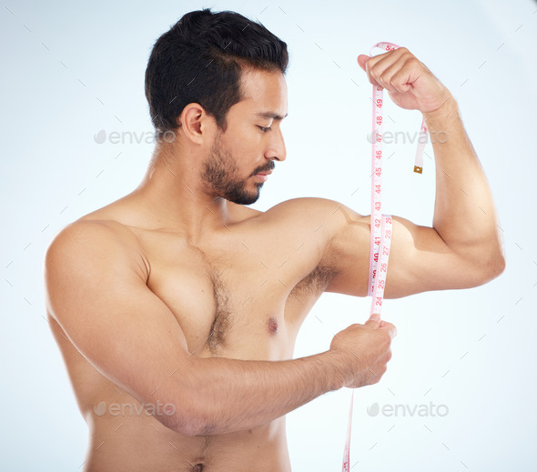 Fitness, body and man with tape measure for biceps in studio on a blue