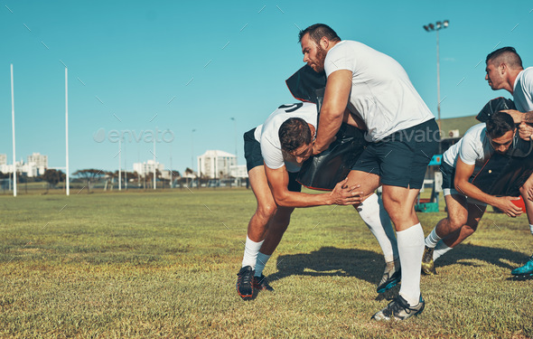 Shot of rugby players training with tackle bags on the field Stock